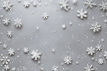 White paper snowflake border on a minimal gray background with copy space creating a winter decoration.