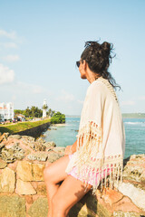 Woman tourist sit enjoy panoramic Lookout from UNESCO Galle Fort. Galle Fort Walk with Ocean Views concept. Sightseeing landmark and popular visit destination in Sri lanka