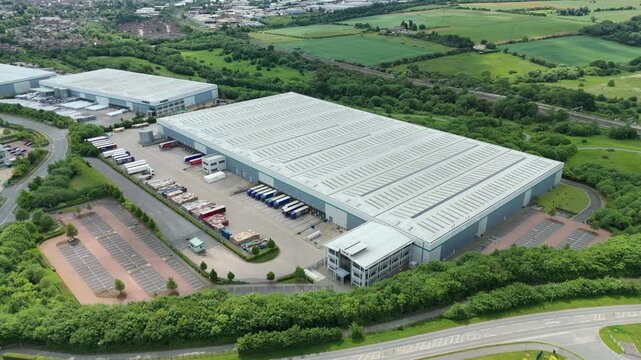 Aerial view drone flight above business park warehouse district factory units data centre quantum computing on a sunny day in the UK logistics and transport of goods economics. 