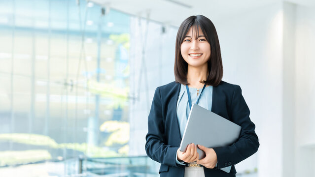 ノートパソコンを持つ笑顔の女性・ビジネスウーマン