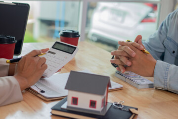 Middle-aged male real estate agent in office analyzes housing documents, signs apartment sale contract, discusses loans, investments, mortgages and property deals with clients.