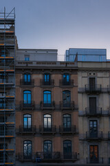 Fototapeta premium Historic Apartment Buildings with Modern Rooftop Structure at Dusk in Barcelona