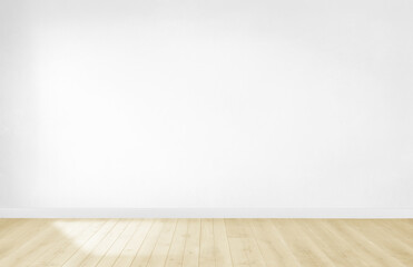 An empty room featuring a beautiful wooden floor and a pristine white wall