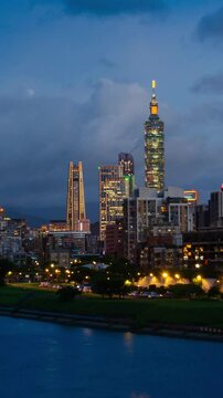 vertical timelapse landscape view of the Taipei capital city of the Taiwan with highrise skyscraper building under sunset twillight sky time with windy cloudy weather modern metropolis big city