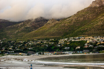 Clouds flowing over the rugged peaks of the Cape Mountains, with a golden glow at the end of the...