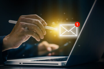 Businessman using digital pen to check email notification on laptop. Symbol of modern communication, digital messaging, and business technology in the online world.