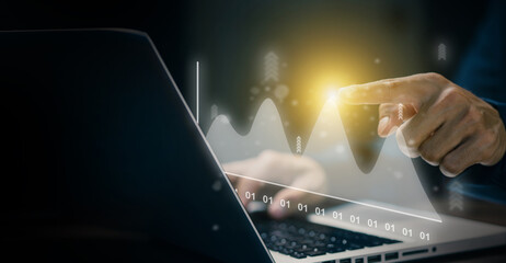 Businessman analyzing virtual graph chart on laptop screen. Concept of data analysis, financial growth, performance tracking, digital technology, and business intelligence.