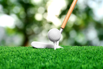 Golf ball on green grass and club outdoors, closeup
