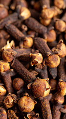 Obraz premium Close-up view of dried cloves reveals their intricate details, showcasing their dark brown hue and unique shapes.