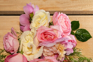 Bouquet of pink roses, peonies on a light wooden background.