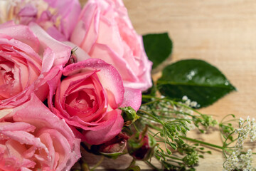 Bouquet of pink roses, peonies on a light wooden background.