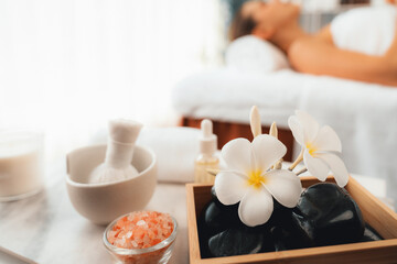 Aromatherapy massage on daylight ambiance or spa salon composition setup with focus decor and spa accessories on blur woman enjoying blissful aroma spa massage in resort or hotel background. Quiescent