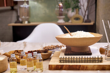 A creative workspace with tools, wax, dried flowers, and a ceramic bowl during the process of making a handmade candle. A cozy and aesthetic DIY moment