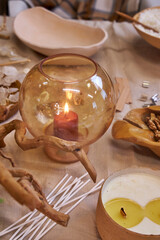 A creative workspace with tools, wax, dried flowers, and a ceramic bowl during the process of making a handmade candle. A cozy and aesthetic DIY moment