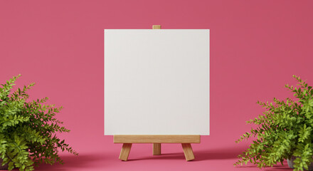 Blank canvas on wooden easel with ferns against a bright pink background in a studio setting
