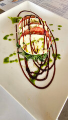 Mozzarella cheese with pesto sauce served with tomatoes in plate