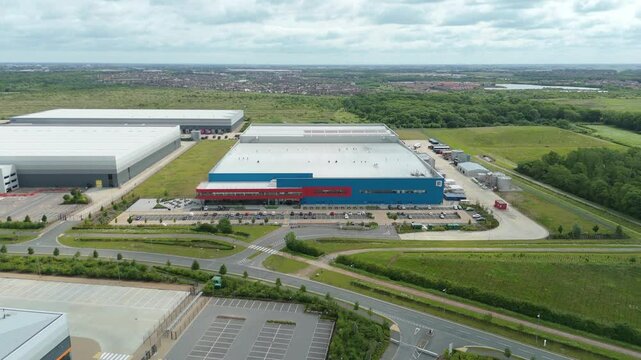Aerial view drone flight above business park warehouse district factory units data centre quantum computing on a sunny day in the UK logistics and transport of goods economics. 