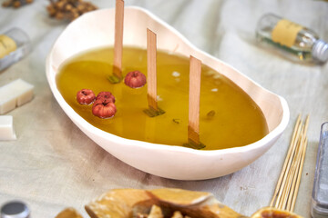 A close-up of freshly poured natural wax in a ceramic bowl with wooden wicks and dried botanicals. The process of creating an eco-friendly handmade aroma candle, combining aesthetics, craftsmanship