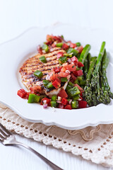 Grilled chicken fillet with asparagus and tomato salsa. Close up.	