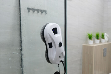 Process of cleaning shower glass from limescale using robot window cleaner and citric acid.