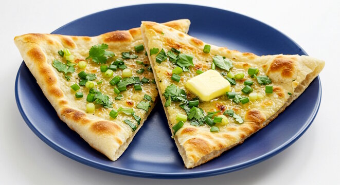 Traditional Indian Punjabi food garlic herb tandoori nan sliced with butter in plate