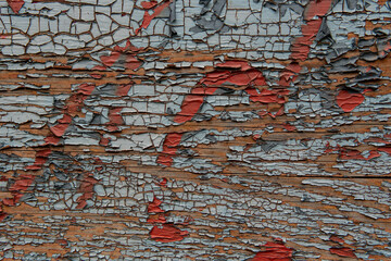 Close-up of peeling paint on an old wooden surface. Cracks and layers reveal aged texture and...