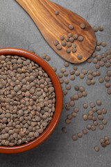 Earthenware bowl full of lentils on a white background in an zenithal photograph
