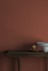 A wooden table with a bowl and candles in front of a red wall