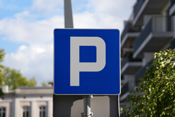 A blue parking sign displayed in an outdoor setting, indicating a designated parking zone.