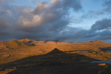 Sunsets on Snaefellsnes peninsula in Iceland, the shadow of The Horn mountain stretches across...