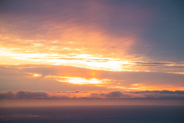 Golden sunrise over the North Atlantic Ocean as seen from Kirkjufell Mountain, Iceland. Soft clouds and glowing skies create a surreal and peaceful Arctic moment