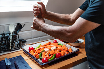 Close-Up of Senior Man Hands Cooking Vegetarian Dish in Bright Kitchen