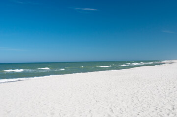 Sandy beach and sea waves by sunny summer day