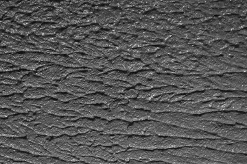 The texture of rough, embossed grey plaster.