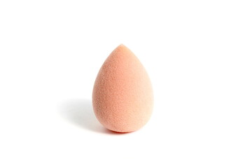 There is a beige makeup sponge on a white background.
