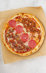 Pepperoni and minced meat pizza with melted mozzarella