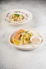 Salmon with vegetables and creamy sauce on elegant plate