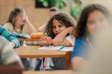 Bored elementary school student during class resting on desk