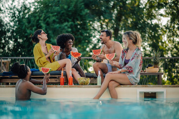 Friends eating watermelon by the poolside during summer vacation