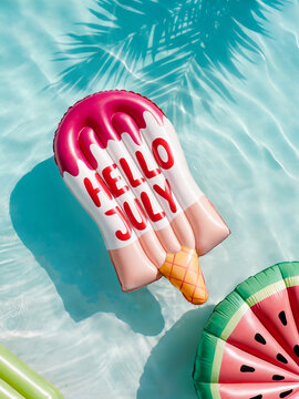 Hello July!  Colorful pool floats arranged in crystal-clear turquoise water. A pink and red ice-cream-shaped inflatable mattress with greeting text and watermelon slice-shaped mattress. 