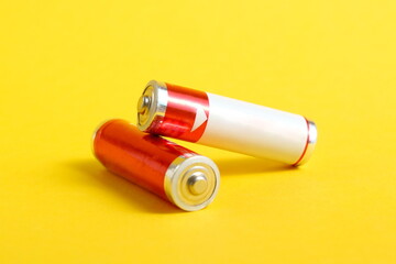 Many saline batteries lie on a yellow background.	