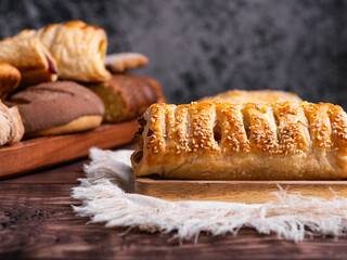 A golden puff pastry with tasty filling, sprinkled with sesame seeds.