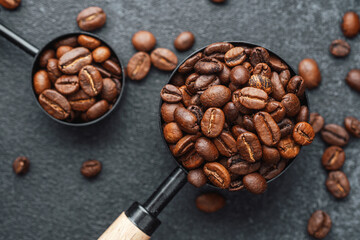 two measuring spoons filled with coffee beans flat lay