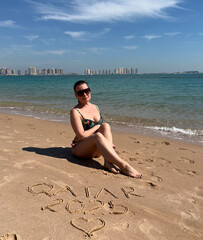 A woman on a clean and modern sandy beach in Doha