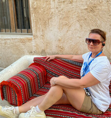 A woman wearing sunglasses poses at the Souk Waqif Market in Doha