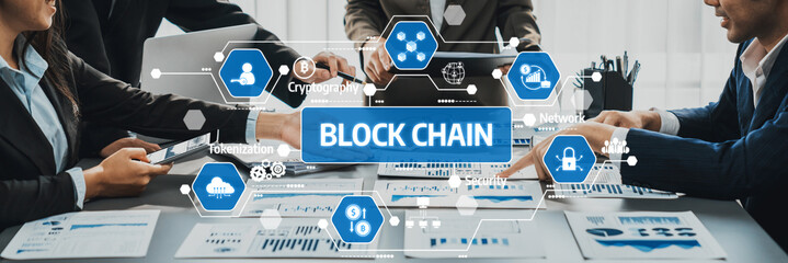 A professional team engages in a collaborative discussion about blockchain technology. Graphical visuals illustrate key concepts in a modern office setting. Amity