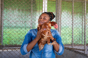 Female farmer with teenager tending chickens in a coop on a small rural farm, local business and agriculture concept.