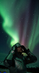 Obraz premium Man In Knight Armor Gazing At The Spectacular Aurora Borealis Against The Starry Night Sky