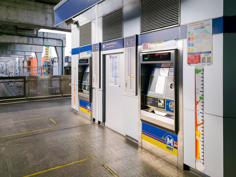 BANGKOK, THAILAND - JUN 27, 2024: Ticket vending machines at a Bangkok MRT station platform with fare maps and instructional signage on the wall.