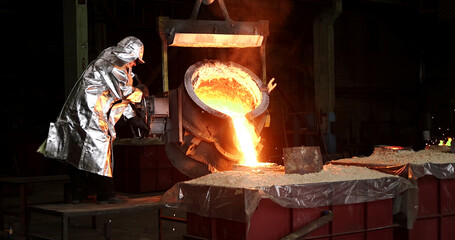 Liquid iron molten metal pouring in container, industrial metallurgical factory, foundry cast, heavy industry	
